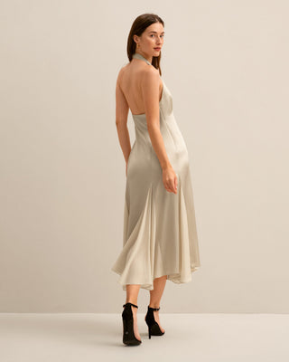 the back view of a woman in a beige dress