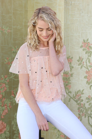 a woman in white jeans and a pink top