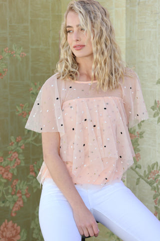 a woman in white jeans and a pink top