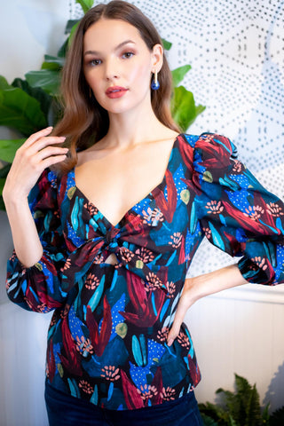 a woman standing in front of a plant