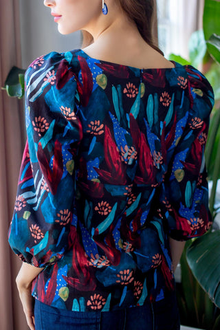 the back view of a woman wearing a floral print top