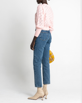 a woman in a pink sweater and jeans