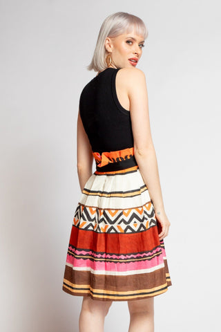 a woman in a black top and multi colored skirt