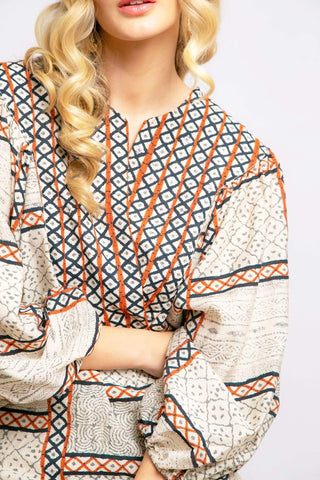 a woman with blonde hair wearing an orange and white patterned top