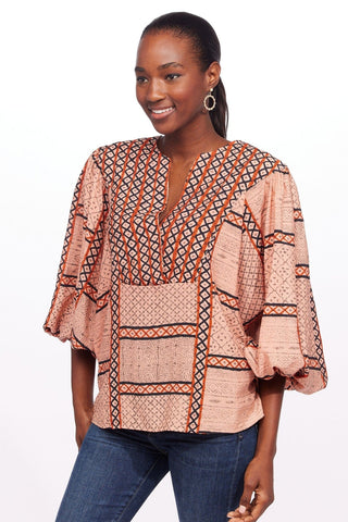 a woman wearing an african print top