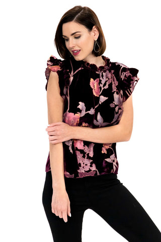 a woman wearing a black top with pink flowers on it