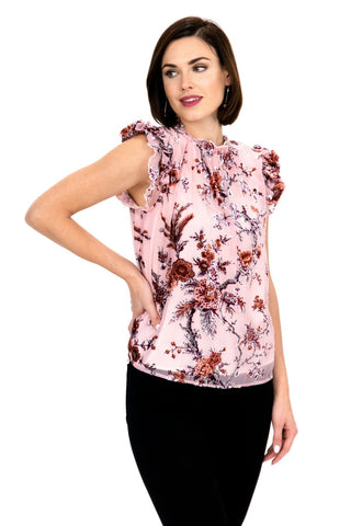 a woman wearing a pink top with a floral print