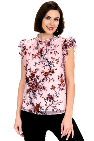 a woman wearing a pink top with floral print