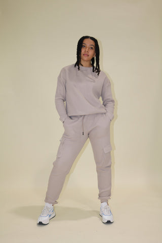 a woman wearing a grey sweatshirt and sweat pants