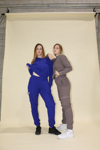 two women standing in front of a white backdrop