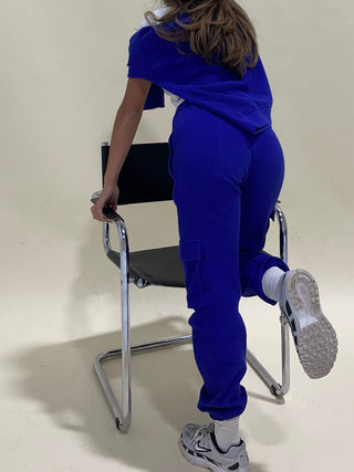 a little girl sitting on a chair in a blue outfit