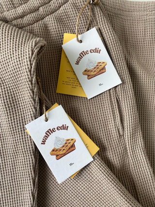 a brown sweater with a tag on it