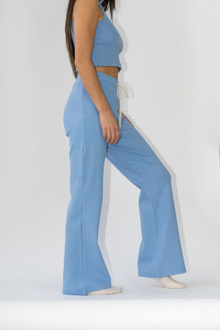 a woman wearing a blue cropped crop top and wide pants